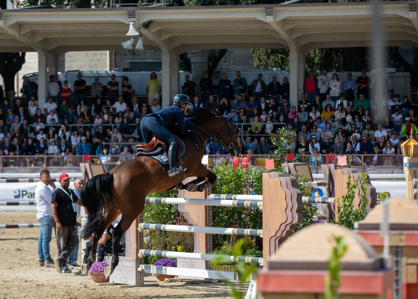 Un binomio in volo sull'ostacolo davanti alla tribuna gremita del Campo Squarcia